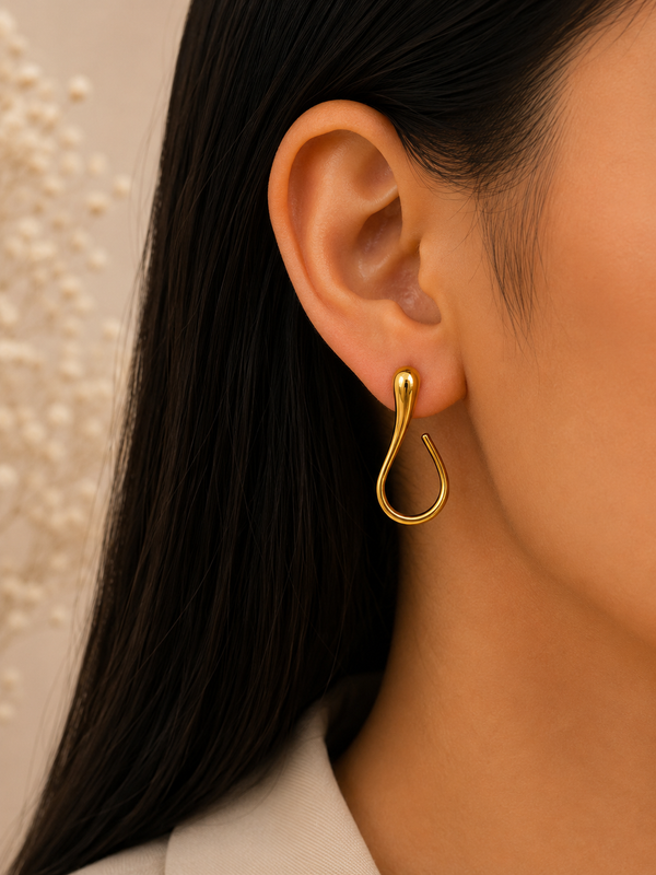 Gold-tone abstract open-hoop statement earring worn on ear