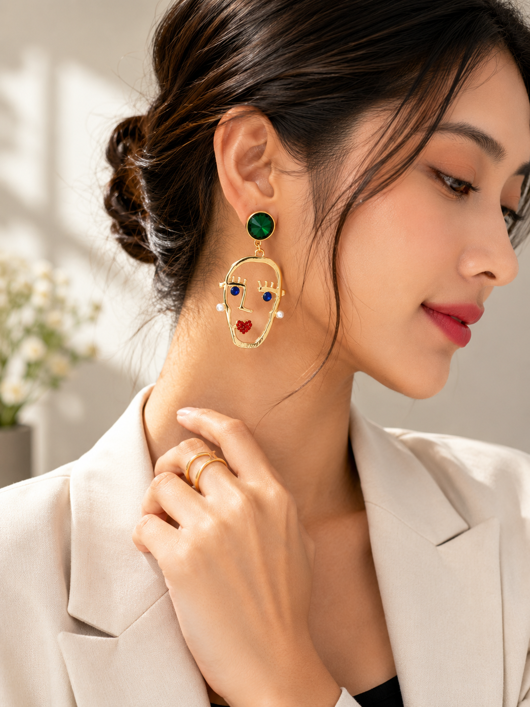 Gold-tone face motif earrings with emerald green and multicolour accents